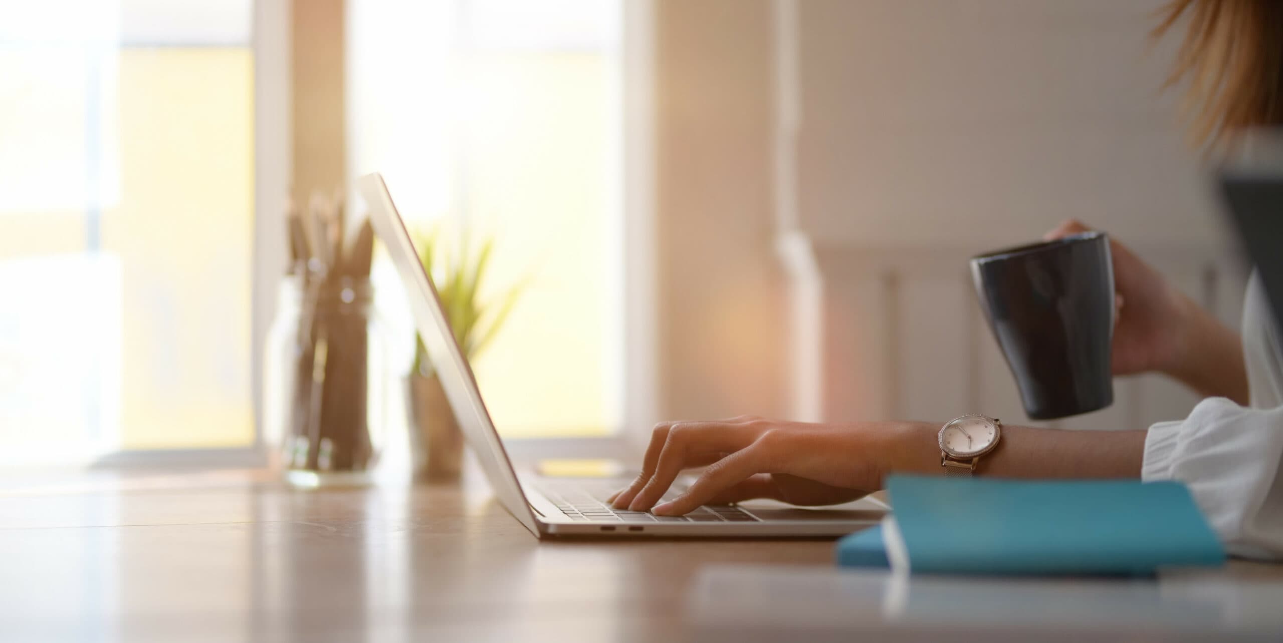 Young businesswoman working with laptop computer and drinking a cup of coffee
